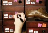  ??  ?? Kiley Rollins works on pricing shoes for the closing sale at Sear’s Shoe Store on Monday in Fort Oglethorpe, Ga.