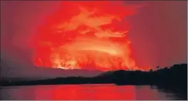  ?? REUTERS ?? Smoke and flames are seen at the Nyiragongo volcanic eruption from the Tchegera Island on Lake Kivu, near Goma, in the Democratic Republic of Congo on Saturday.