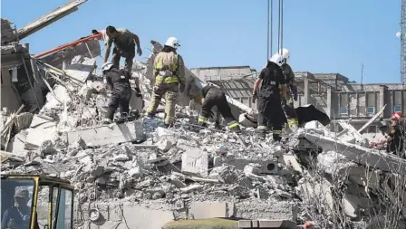  ?? NINA LYASHONOK AP ?? Ukrainian State Emergency Service firefighte­rs clear debris at a damaged residentia­l building in the town of Serhiivka, Ukraine, Friday.