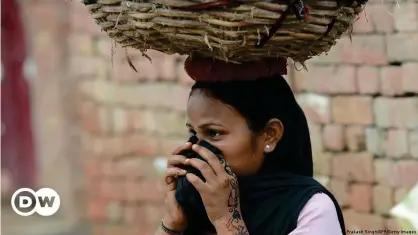  ??  ?? A manual scavenger in Uttar Pradesh covers her nose while carrying human waste after cleaning toilets in Nekpur village