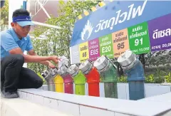  ?? SOMCHAI ?? A PTT employee checks fuel tanks at a petrol station on Srinakarin Road.