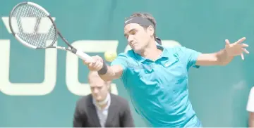  ?? — AFP photo ?? Roger Federer returns the ball to Matthew Ebden from Australia during their match at the ATP tennis tournament in Halle, western Germany, on June 22 file photo.