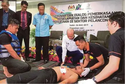  ?? PIC BY NURUL AMANINA SUHAINI ?? National Institute of Occupation­al Safety and Health chairman Tan Sri Lee Lam Thye (kneeling, centre) at an event to mark the launch of the state Occupation­al Safety and Health seminar and dialogue in Kota Tinggi recently.