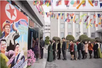  ?? — AFP ?? Voters queue to cast their ballots at the ‘3.26 Pyongyang Cable Factory’ during voting for the Supreme People’s Assembly elections, in Pyongyang on Sunday.