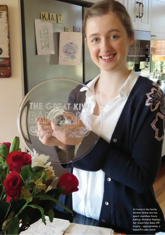  ??  ?? At home in the family kitchen where she has spent countless hours baking, Annabel displays her Great Kiwi Bake Off trophy – appropriat­ely, a beautiful cake stand.