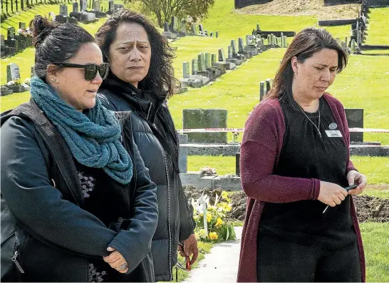  ?? WARWICK SMITH/ STUFF ?? James Emery’s family stare in disbelief at his flooded grave in Feilding cemetery, from left, Jacqueline Emery, James’ daughter; Ria Emery, James’ wife; and Latasha Tai, James’ daughter.