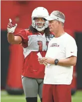  ??  ?? Cardinals wide receiver Larry Fitzgerald talks to offensive coordinato­r Mike McCoy during training camp on Aug. 15.