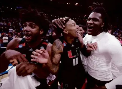  ?? JAMIE SQUIRE/GETTY IMAGES ?? Norchad Omier (left) appeared to be as surprised as anybody by Miami’s comeback win in the Midwest Region final as he celebrated with Jordan Miller (center) and the Hurricanes.