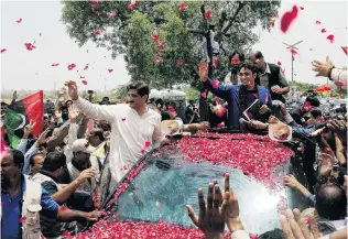  ?? PHOTO: REUTERS ?? Adulation . . . Bilawal Bhutto Zardari (in blue) receives a rosepetal welcome from supporters as he heads to a campaign rally on the outskirts of Karachi.