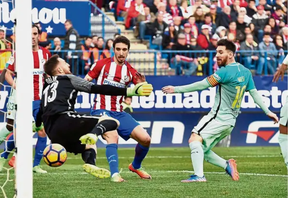  ??  ?? That one’s going in: Lionel Messi (right) slots in Barcelona’s second goal against Atletico Madrid in the La Liga match at the Vicente Calderon yesterday. Barcelona won 2-1. — AFP