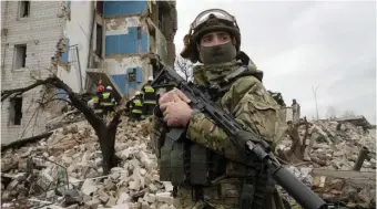  ?? Ap ?? ‘WE WILL DO EVERYTHING TO WIN’: A Ukrainian soldier stands near an apartment ruined from Russian shelling in Borodyanka, Ukraine yesterday.