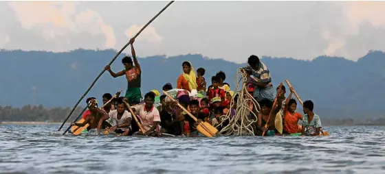  ?? —REUTERS ?? ESCAPE FROMMYANMA­R Rohingya refugees escaping from military atrocities in Myanmar cross the Naf River with an improvised raft to reach Teknaf in Bangladesh.