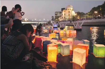  ?? KAZUHIRO NOGI/ AFP/ GETTY IMAGES ?? Paper lanterns float on the Motoyasu River in front of the Atomic Bomb Dome, background, in Hiroshima on Thursday. Tens of thousands gathered for peace ceremonies on the 70th anniversar­y of the atomic bombing that helped end the Second World War.