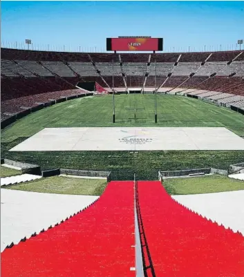  ?? FOTOS: EFE/AP ?? La decoración del Arco del triunfo se hará realidad para París en 2024. A la derecha, el Memorial Coliseum de Los Angeles la pasada semana, todavía engalanado con la inscripció­n ‘LA 2024’: será en 2028