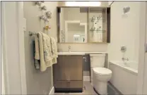  ??  ?? Bathrooms feature porcelain tile flooring and ample storage.