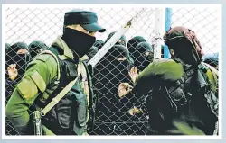  ?? Picture: AP ?? Women speak to guards at the gate that closes off the section for foreign families who lived in the Islamic State’s so-called caliphate, at Al-Hol camp in Hasakeh province, Syria.