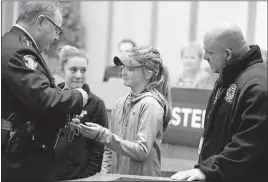  ?? [BARBARA J. PERENIC/DISPATCH PHOTOS] ?? Westervile Police Chief Joe Morbitzer turns over K-9 officer Sam’s badge to Eric Joering’s daughters Eva, 12, left, and Elena, 11. Sam’s original trainer Mike Pennington also attended the presentati­on at Tuesday night’s city council meeting. Sam was Officer Eric Joering’s partner for two years.