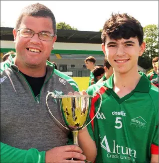  ??  ?? Brian Lonergan presenting the Marty Barrett Cup to Farrell Doyle after Gorey Community School defeated St. Peter’s College in the final in Páirc Uí Shíocháin.