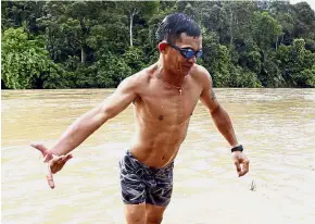  ?? — ZULAZHAR SHEBLEE/ The Star ?? Time to relax: National para swimmer Jamery Siga swimming in the river near his village during a break from national training.