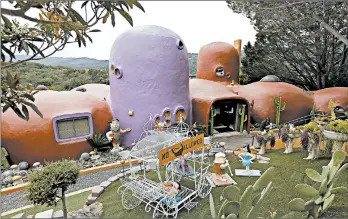  ?? ERIC RISBERG/AP ?? The San Francisco suburb of Hillsborou­gh is suing the owner of this Flintstone House, which has statues of Fred and Wilma, along with Barney and Betty Rubble, in the front.