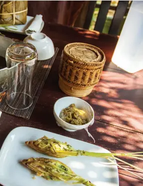  ??  ?? Left: The food the author cooked at the Tamarind cooking class in Luang Prabang. Includes mok pa in the banana leaf, orlarm in the pan, and ua si khai deepfried lemongrass stuffed with minced chicken. Below: An old woman fries corn cakes at the market...