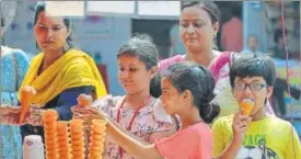  ?? DEEPAK GUPTA / HT PHOTO ?? ▪ Kids enjoying icecream to counter the afternoon heat in Lucknow.