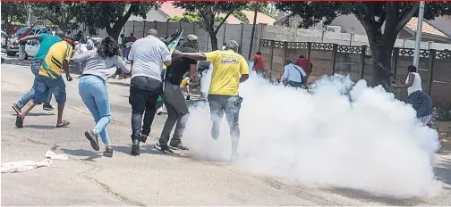  ?? Pictures: Nigel Sibanda, Yeshiel Panchia ?? CRYING EYES. Mandla Khumalo, top, cries at Florida Primary School on his first day yesterday and, bottom, ANC and EFF protesters flee as police deploy stun grenades and tear gas outside Hoërskool Overvaal in Vereenigin­g.