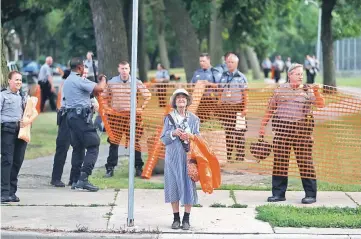  ??  ?? An elderly woman waits for the bus as members of the Milwaukee County Sheriff’s department erect a fence around Sherman Park after disturbanc­es following the police shooting of a man in Milwaukee, Wisconsin, US. — Reuters photo