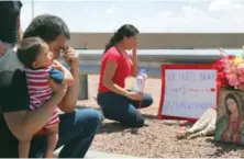  ?? AP ?? Julio Novoa con su hijo y Danielle Novoa, a la derecha, se arrodillan en la escena del tiroteo masivo en El Paso, Texas.