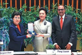  ?? XIE HUANCHI /XINHUA NEWS AGENCY ?? WHO Director-General Margaret Chan (left) presents a medal for outstandin­g service to first lady Peng Liyuan as UNAIDS Executive Director Michel Sidibe looks on.