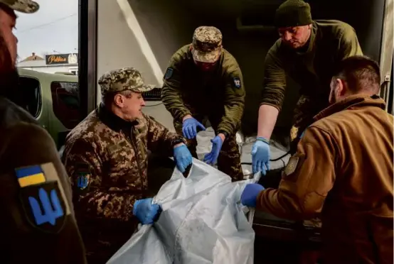  ?? NIcOlE tuNG/NEW YORK tImES ?? Members of On The Shield, an organizati­on that collects bodies of slain soldiers, worked at a morgue in the Donetsk region.