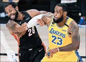  ?? MARK J. TERRILL/AP ?? LeBron James battles the Heat’s Andre Iguodala in the Lakers’ win Tuesday.