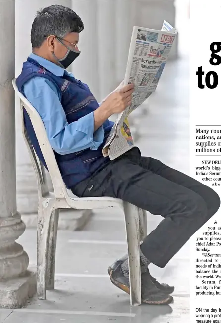  ?? MONEY SHARMA/AGENCE FRACE-PRESSE ?? ON the day India’s coronaviru­s cases passed 11 million Monday, a man wearing a protective mask, nonchalant­ly reads a newspaper as a preventive measure against the deadly scourge.