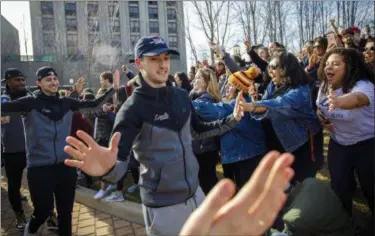  ?? BRIAN CASSELLA — CHICAGO TRIBUNE VIA AP ?? Loyola guard Clayton Custer and teammates greet fans as they welcome the Ramblers back to campus on March 18 in Chicago, after the team advanced to the Sweet 16 of the NCAA Tournament in their first appearance since 1985.