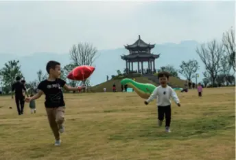  ??  ?? Children play at a park in the Three Gorges reservoir region in Yichang, Hubei Province in central China, on October 1