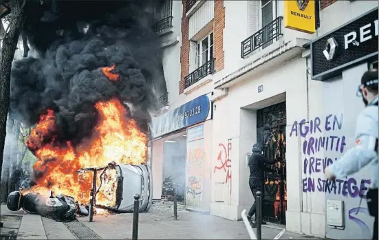  ?? CHRISTIAN HARTMANN / REUTERS ?? Un cotxe crema davant un concession­ari Renault durant els disturbis del Primer de Maig a París