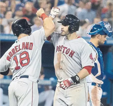  ?? FRED THORNHILL/THE CANADIAN PRESS ?? Boston Red Sox outfielder J.D. Martinez is greeted at home plate by teammate Mitch Moreland after his three-run homer in the 8th inning began a Red Sox comeback over the Jays. The Sox won 10-7 in 10 innings at the Rogers Centre. Story, S4