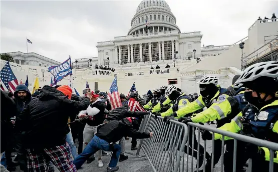  ?? AP ?? Protesters try to break through a police barrier at the Capitol in Washington.