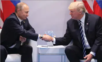  ??  ?? Russian President Vladimir Putin shakes hands with US President Donald Trump during their bilateral meeting at the G20 Summit in Hamburg, Germany, yesterday