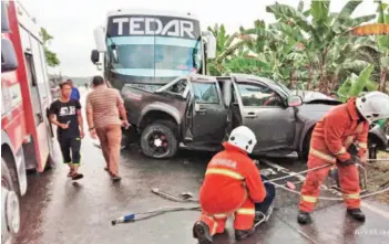  ??  ?? Fire and Rescue personnel at the scene of the accident at Km 15, Lahad Datu-Sandakan road.