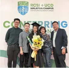  ?? ?? Dr Low with her family during her conferring ceremony in Penang.