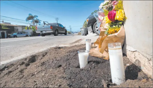  ?? Richard Vogel The Associated Press ?? Candles and flowers are placed along Pacific Coast Highway, after a crash killed four college students and injured two others.