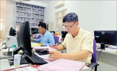  ?? CHBAR AMPOV OWSO ?? One Window Service Office (OWSO) officials prepare civil registrati­ons for people in the capital’s Chbar Ampov district on February14.