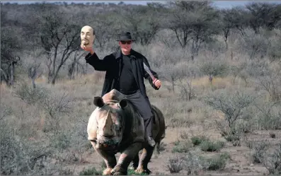  ??  ?? Home on the range... Ben Trovato gets the feel of rhino herding and farming in the bundu. He advocates getting guard rhinos to reduce poverty and crime.