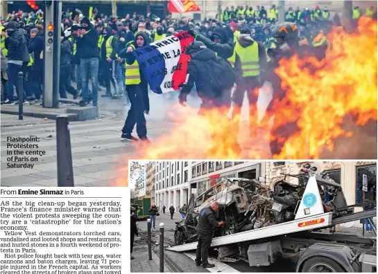  ??  ?? Flashpoint: Protesters in the centre of Paris on Saturday Clearing up: A burnt-out car is loaded onto a trailer yesterday in the capital