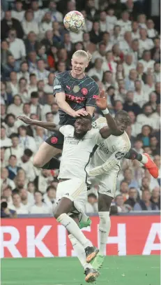  ?? — AFP ?? Manchester City’s Norwegian striker Erling Haaland (on top) heads the ball next to Real Madrid’s German defender Antonio Rudiger and French defender Ferland Mendy at the Santiago Bernabeu Stadium in Madrid.