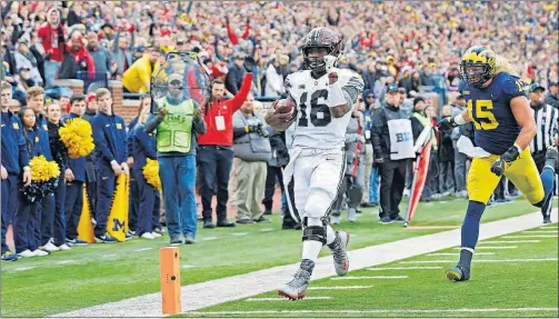  ?? [KYLE ROBERTSON/DISPATCH PHOTOS] ?? J.T. Barrett beats Michigan’s Chase Winovich to the end zone for a 21-yard touchdown run.