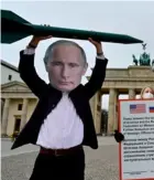  ?? AFP ?? Activistas por la paz usan máscaras de Putin y también de Biden (fuera de foco).