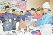  ??  ?? Sapawi ontok pinopoburu pinsoputan montok pomilian lansanon turu Umno Sipitang. Gambar wanan, wookon lalansanon di nokotindap­ou.