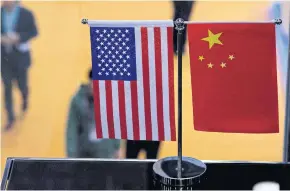  ?? AFP ?? In this file photo taken on Nov 6, 2018 a Chinese and US flag are displayed at a booth during the first China Internatio­nal Import Expo in Shanghai.